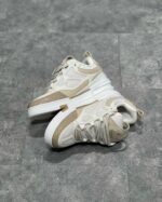 Sneakers bianche moderne con dettagli beige, suola elevata e traspirante per stile e comfort.