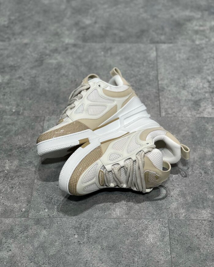 Sneakers bianche moderne con dettagli beige, suola elevata e traspirante per stile e comfort.