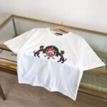 T-shirt bianco con logo colorato, cane stilizzato e dettagli eleganti su sfondo minimalista.