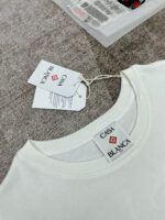 T-shirt bianco casual con etichette marca CASA BLANCA, semplice e elegante, per uno stile versatile.