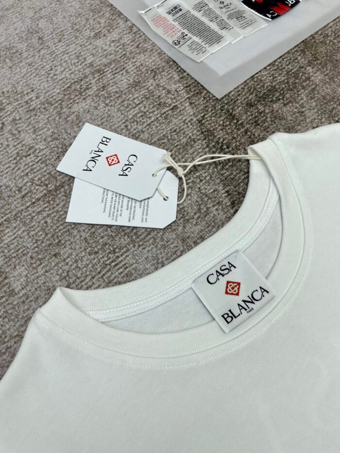 T-shirt bianco casual con etichette marca CASA BLANCA, semplice e elegante, per uno stile versatile.