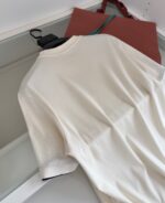 T-shirt bianca casual con borsa marrone elegante, stile minimalista e look versatile.