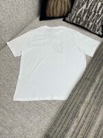 T-shirt bianco casual su divano con cuscini decorativi, stile minimalista e comfort quotidiano.