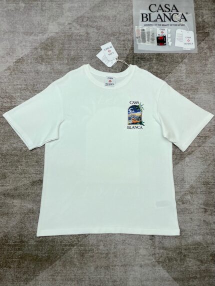 T-shirt bianco con grafica spiaggia, tramonto e palme, stile casual e fresco.
