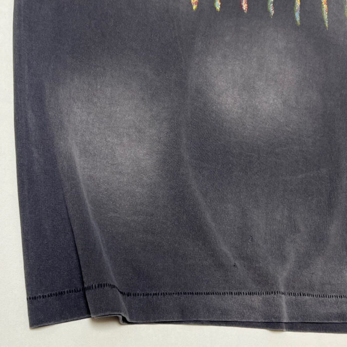 T-shirt grigia usurata con design colorati vivaci e cuciture di qualità.