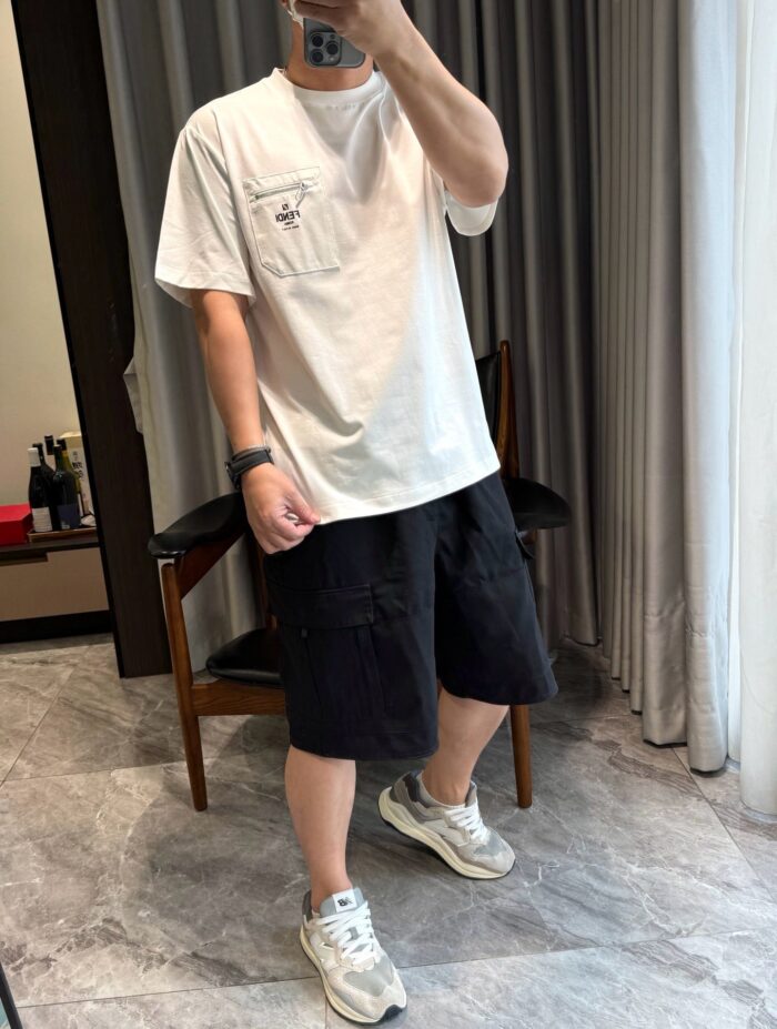 Giovane in abbigliamento casual con shorts e sneakers in ambiente moderno e luminoso.