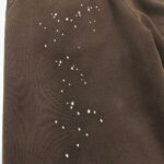 Tessuto corduroy marrone con stelle bianche, ispirato al cielo notturno e alla magia celestiale.