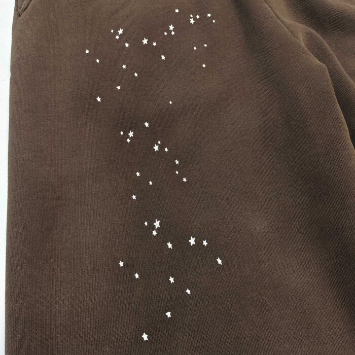 Tessuto corduroy marrone con stelle bianche, ispirato al cielo notturno e alla magia celestiale.