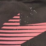 Maglietta nera con strisce rosa e stelle cosmiche, stile moderno e cosmico.