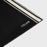 Sciarpa Celine nera con strisce bianche e logo elegante in stile minimalista.