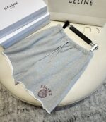 Shorts grigi CELINE con logo, dettaglio raw hem, stile casual di alta moda.