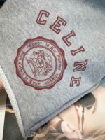 Felpa Celine con logo ricamato e emblema vintage in grigio e bordeaux elegante.
