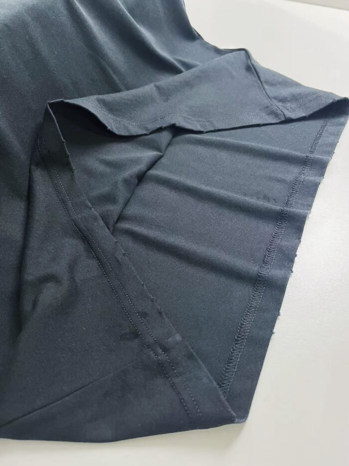 Tessuto grigio morbido e dettagli di sartoria su camicia minimalista e versatile.