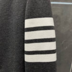 Manica di felpa grigia con strisce bianche sportive, stile casual e dinamico.