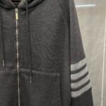 Felpa grigia con zip, cappuccio e dettagli a strisce sportive, comoda e moderna.