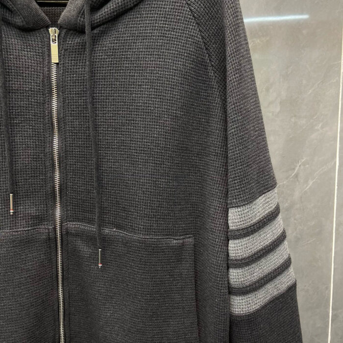 Felpa grigia con zip, cappuccio e dettagli a strisce sportive, comoda e moderna.