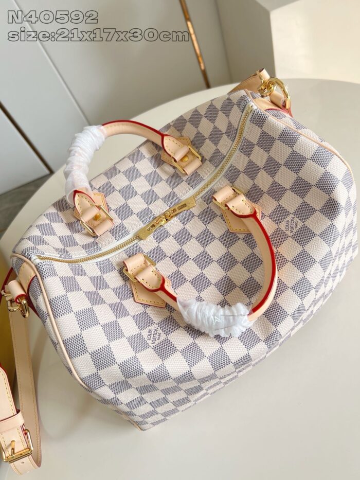 Borsa a quadri pastello con manici in pelle, dettagli dorati e stile elegante e moderno.