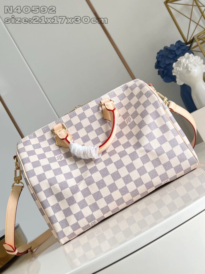 Borsa elegante con motivo checkerboard, manici in pelle, tracolla regolabile e dettagli raffinati.