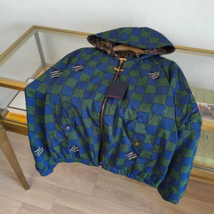 Giacca sportiva a quadri blu e verde con cappuccio e zip, stile moderno e vivace.