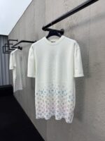 T-shirt bianca moderna con design pastello e motivo artistico, perfetta per uno stile elegante e casual.