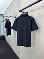 Magliette polo nere minimaliste su supporti eleganti, stile semplice e raffinato per ogni occasione.