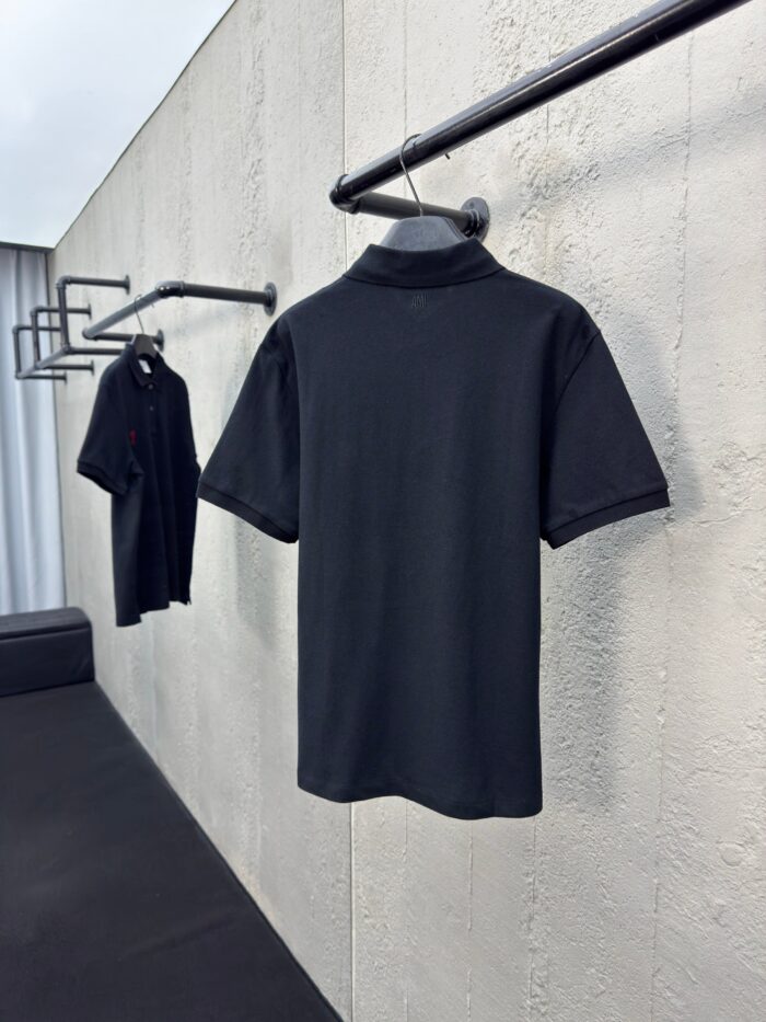 Magliette polo nere minimaliste su supporti eleganti, stile semplice e raffinato per ogni occasione.