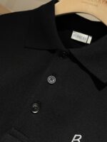 Polo nera Burberry, elegante, in tessuto di alta qualità con bottoni e Logo discreto.
