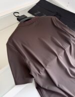 Maglietta marrone elegante su gancio, stile minimalista, perfetta per look casual e sofisticati.