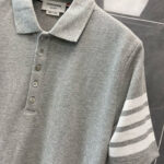 Maglietta polo grigia con manica a strisce, stile casual elegante e comfort classico.