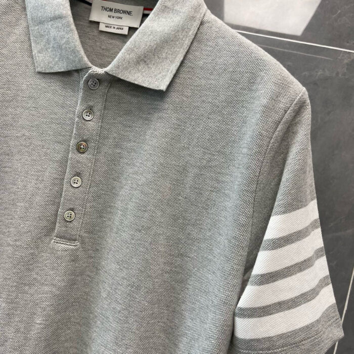 Maglietta polo grigia con manica a strisce, stile casual elegante e comfort classico.