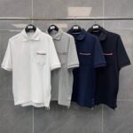 Set di polo classiche neutre: bianco, grigio, navy e nero su sfondo grigio chiaro.