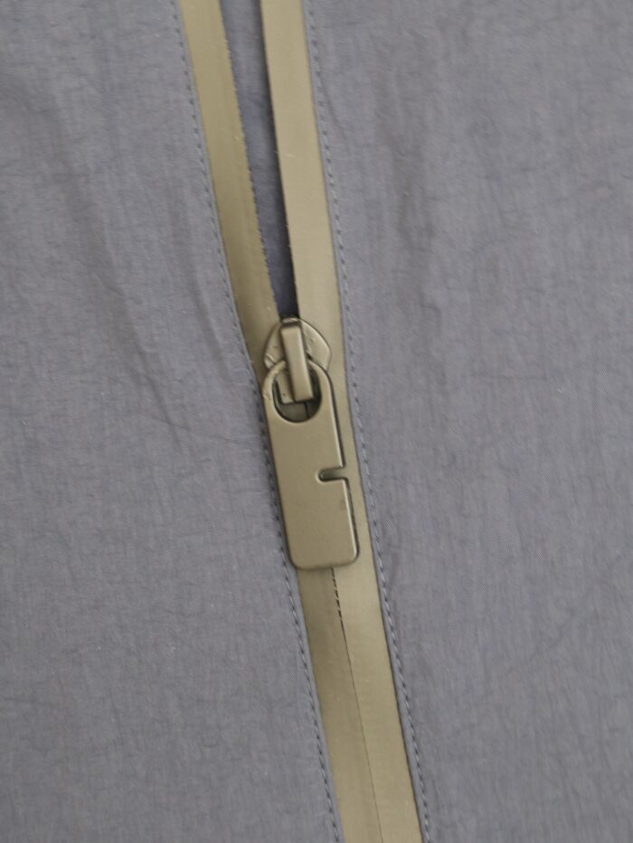 Chiusura lampo elegante e semplice su tessuto morbido, con dettagli precisi e funzionali.