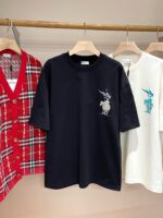 Vetrina moda con T-shirt nera, cardigan a quadri rosso e camicia bianca con design cavaliere.