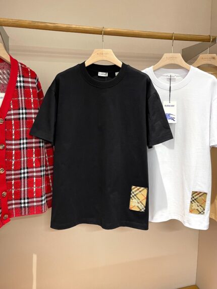 Vetrina con camicie casual, patch colorati e design semplice in nero, rosso e bianco.