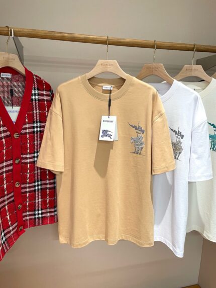 Vetrina minimalista con t-shirt grafici e cardigan a quadri in boutique elegante.