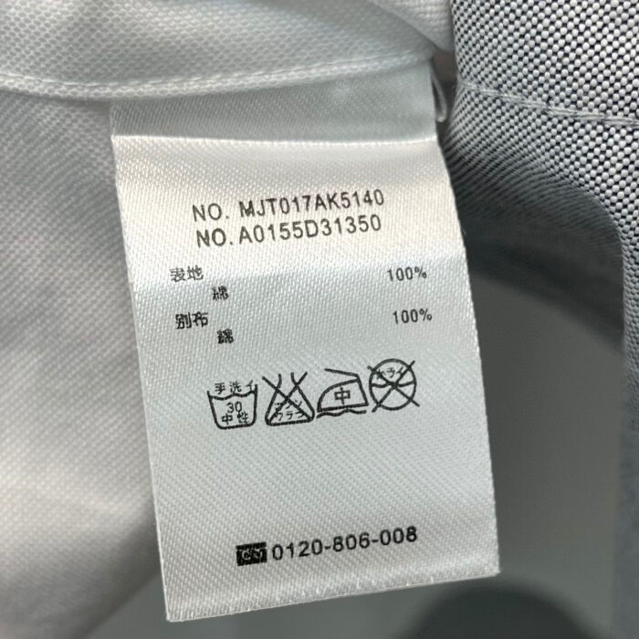 Etichetta di cura in polyester con simboli di lavaggio e dettagli di contatto.
