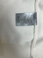 Etichetta di cura interna su maglione in maglia morbida, dettagli e istruzioni di lavaggio visibili.