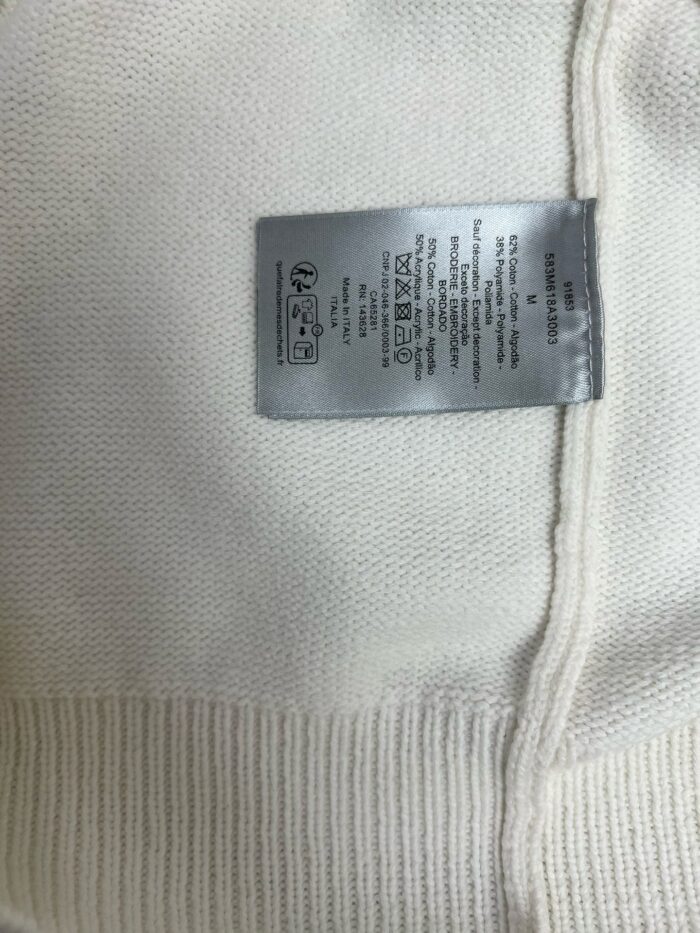 Etichetta di cura interna su maglione in maglia morbida, dettagli e istruzioni di lavaggio visibili.
