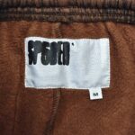 Etichetta felpa marrone con logo artistico e taglia M, casual e di alta qualità.