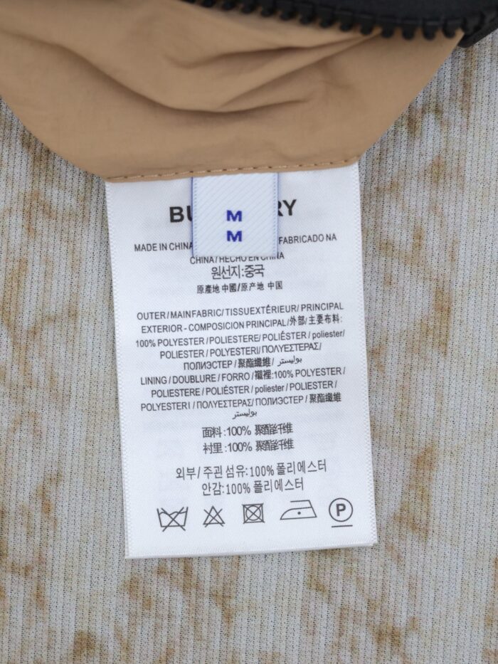 Etichetta Burberry Taglia M con istruzioni di cura e composizione dei materiali.
