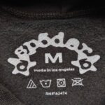 Etichetta di abbigliamento Spoder, taglia M, Made in Los Angeles, con dettagli cura.