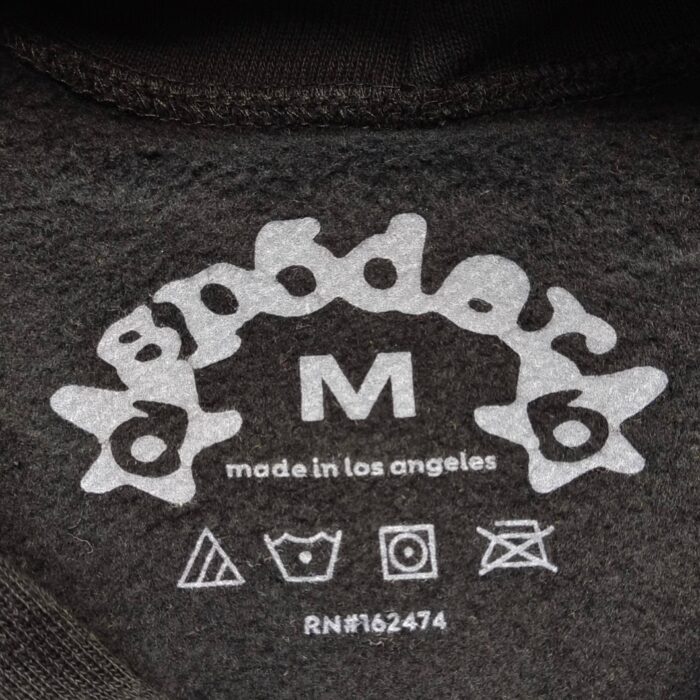 Etichetta di abbigliamento Spoder, taglia M, Made in Los Angeles, con dettagli cura.