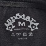 Etichetta moda Spoder, taglia M, Made in Los Angeles, con simboli di cura tessuto.