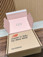 Scatola di lusso Miu Miu e New Balance, interno rosa elegante e design raffinato.