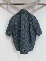 Camicia casual a quadri verde e blu con logo sul retro, stile moderno e versatile.