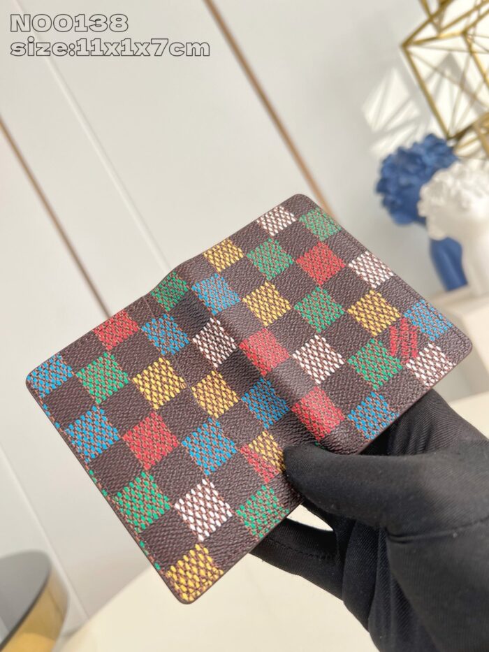 Portafoglio elegante con pattern a quadri colorati, maneggiato con guanto in contesto moderno.