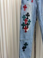 Jeans in denim con croci colorate, asimmetriche, stile giovane e creativo.
