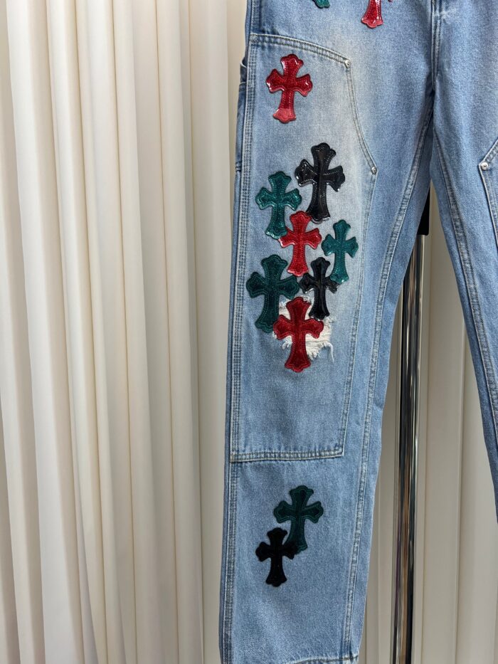 Jeans in denim con croci colorate, asimmetriche, stile giovane e creativo.