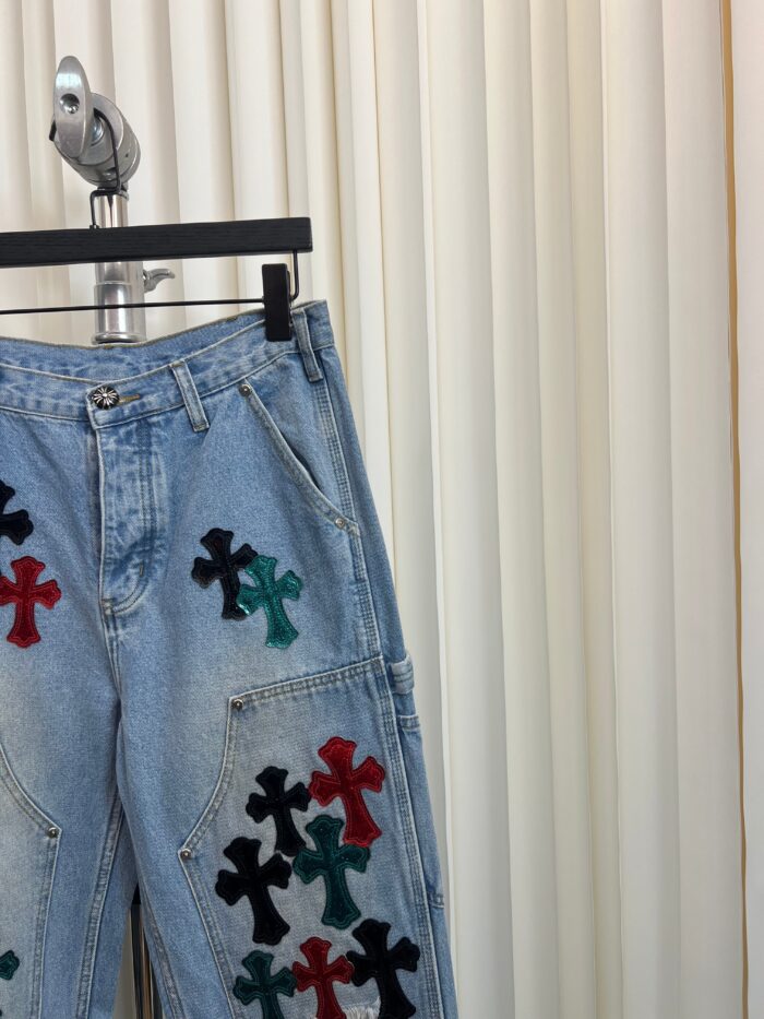 Jeans denim azzurri con croci colorate e dettagli cargo, stile casual ed eclettico.