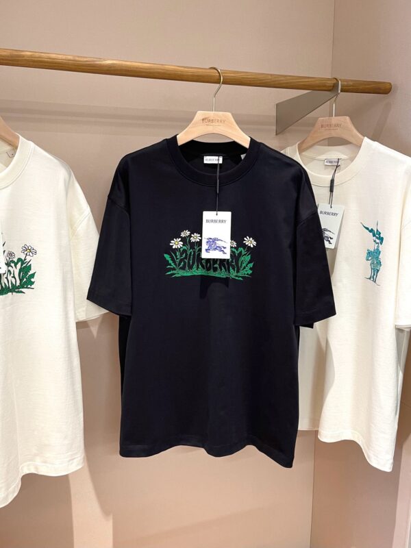 Esposizione di T-shirt con ricami, grafiche colorate e stile moderno in negozio.